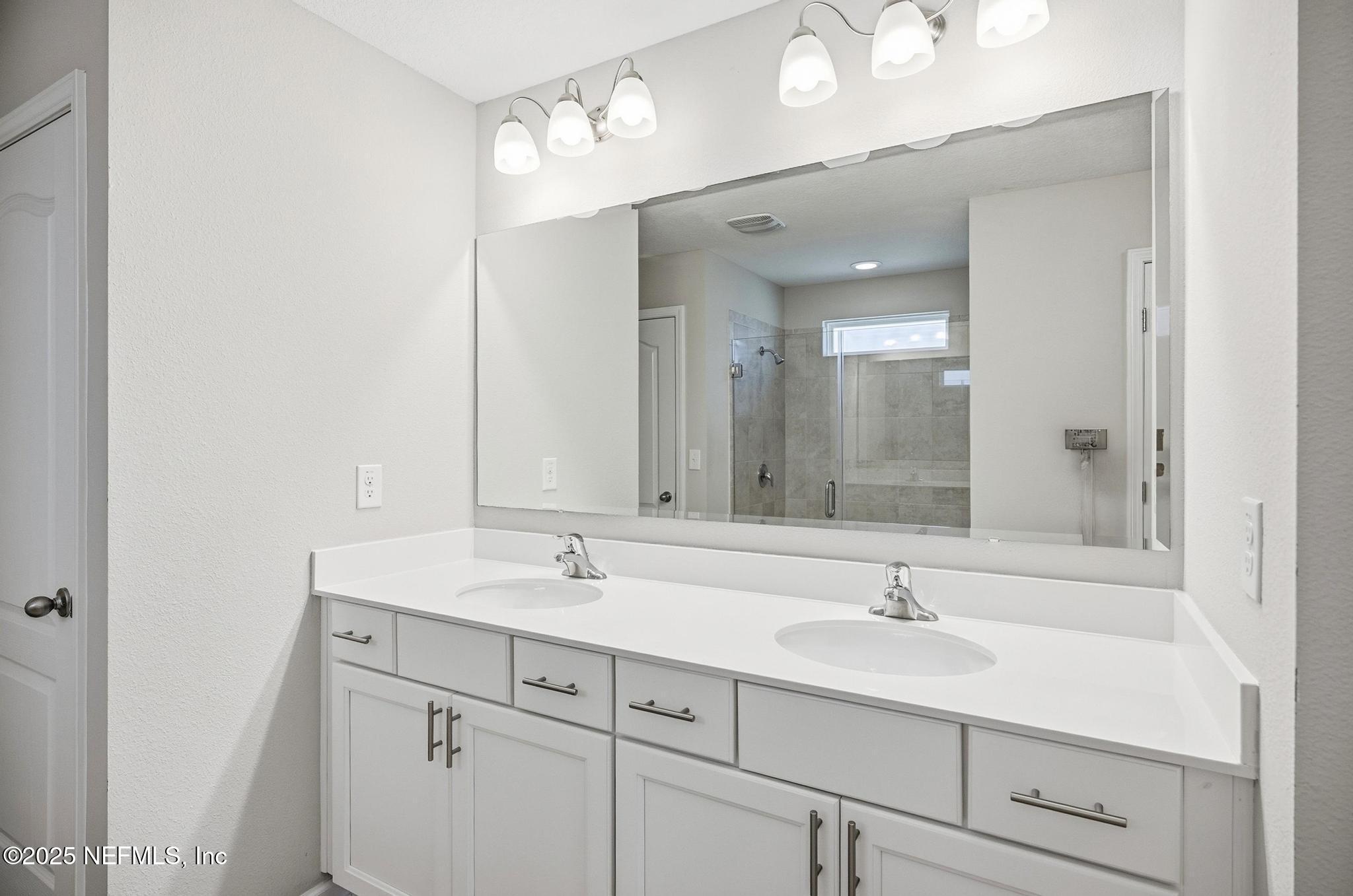 83 Hummingbird Court Palm Coast, FL 32164 - Photo 16 of 70 a bathroom with a sink double vanity and a mirror