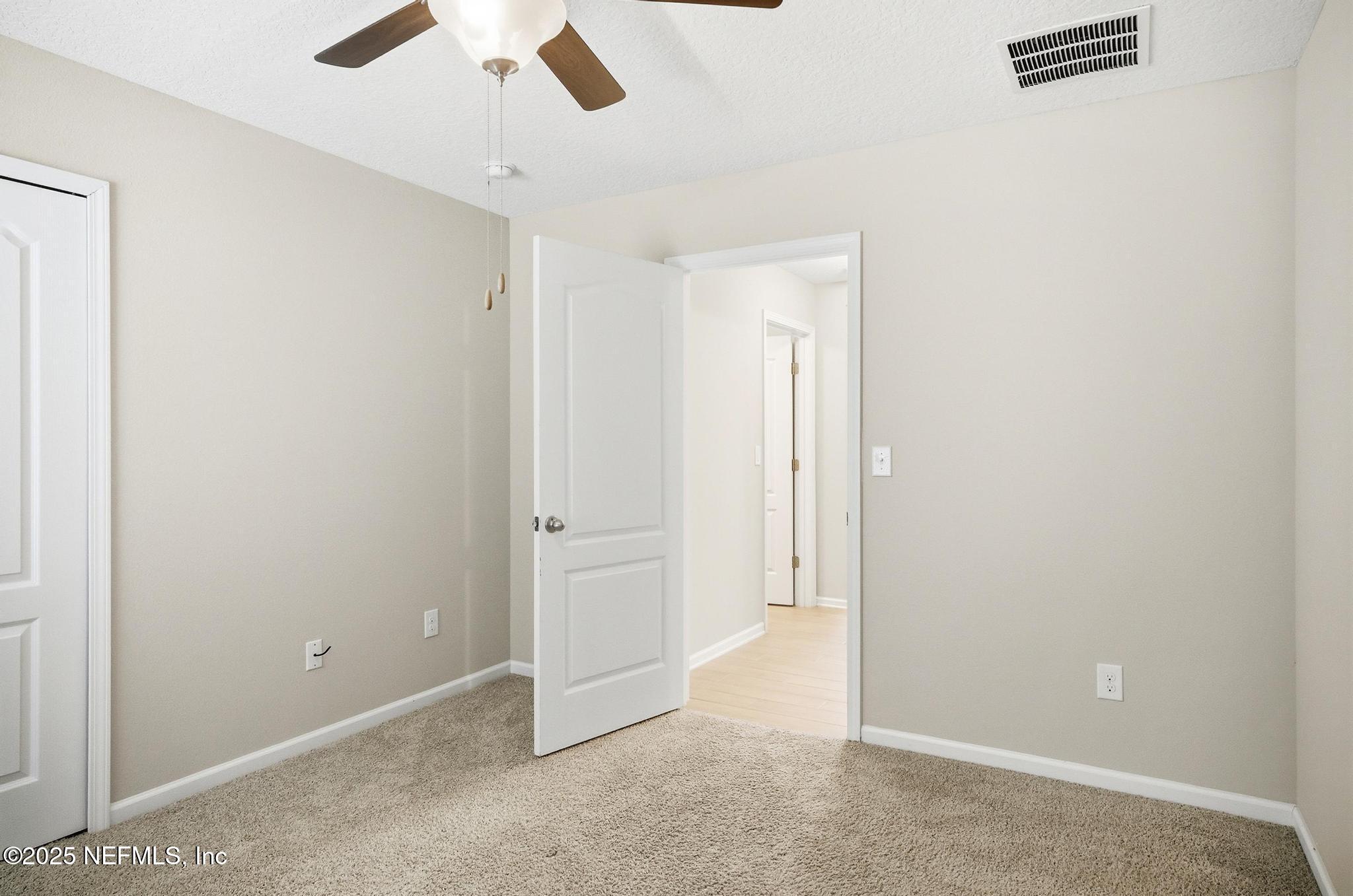 83 Hummingbird Court Palm Coast, FL 32164 - Photo 23 of 70 an empty room with ceiling fan and window