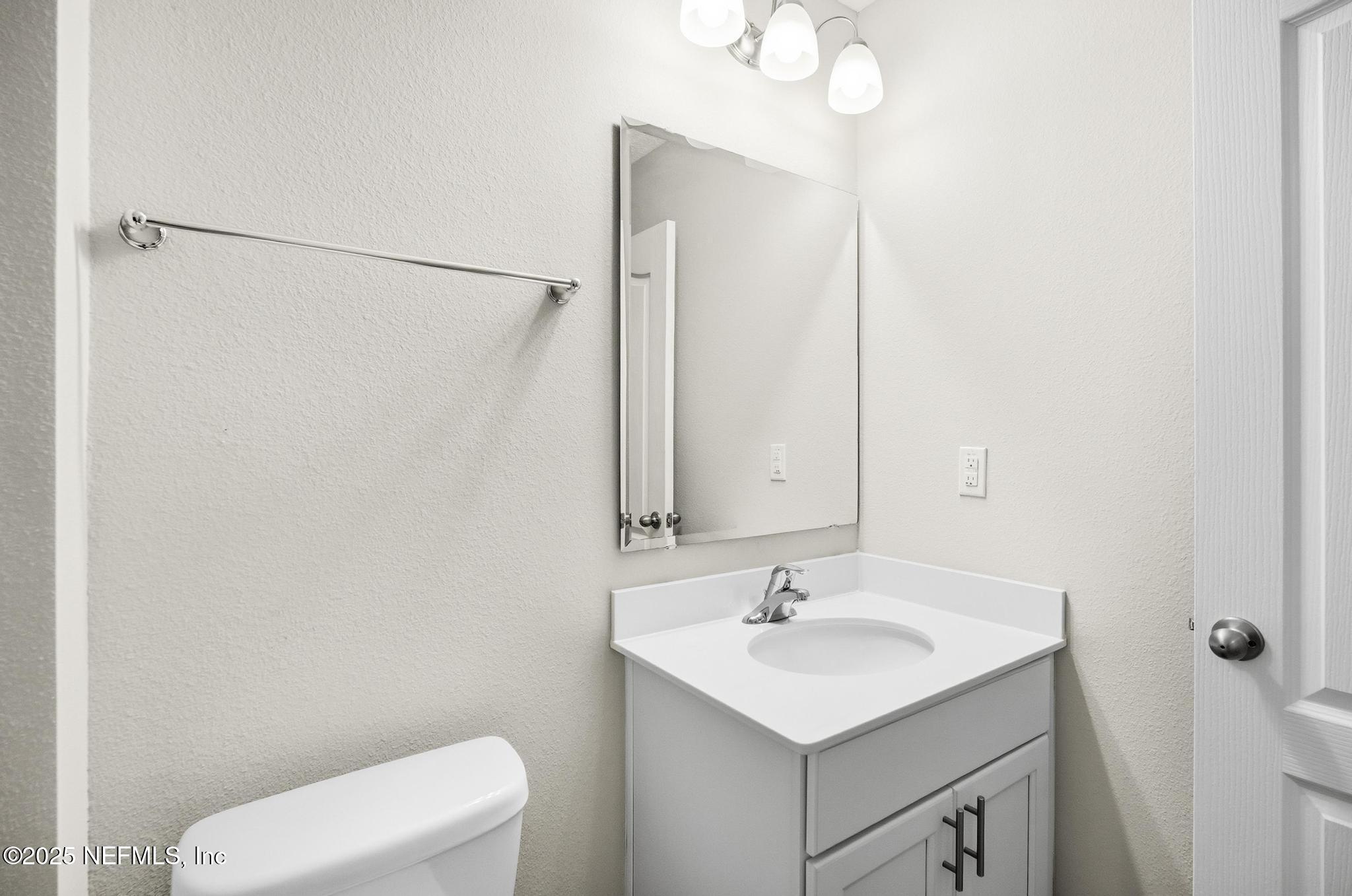 83 Hummingbird Court Palm Coast, FL 32164 - Photo 25 of 70 a bathroom with a sink a toilet and mirror
