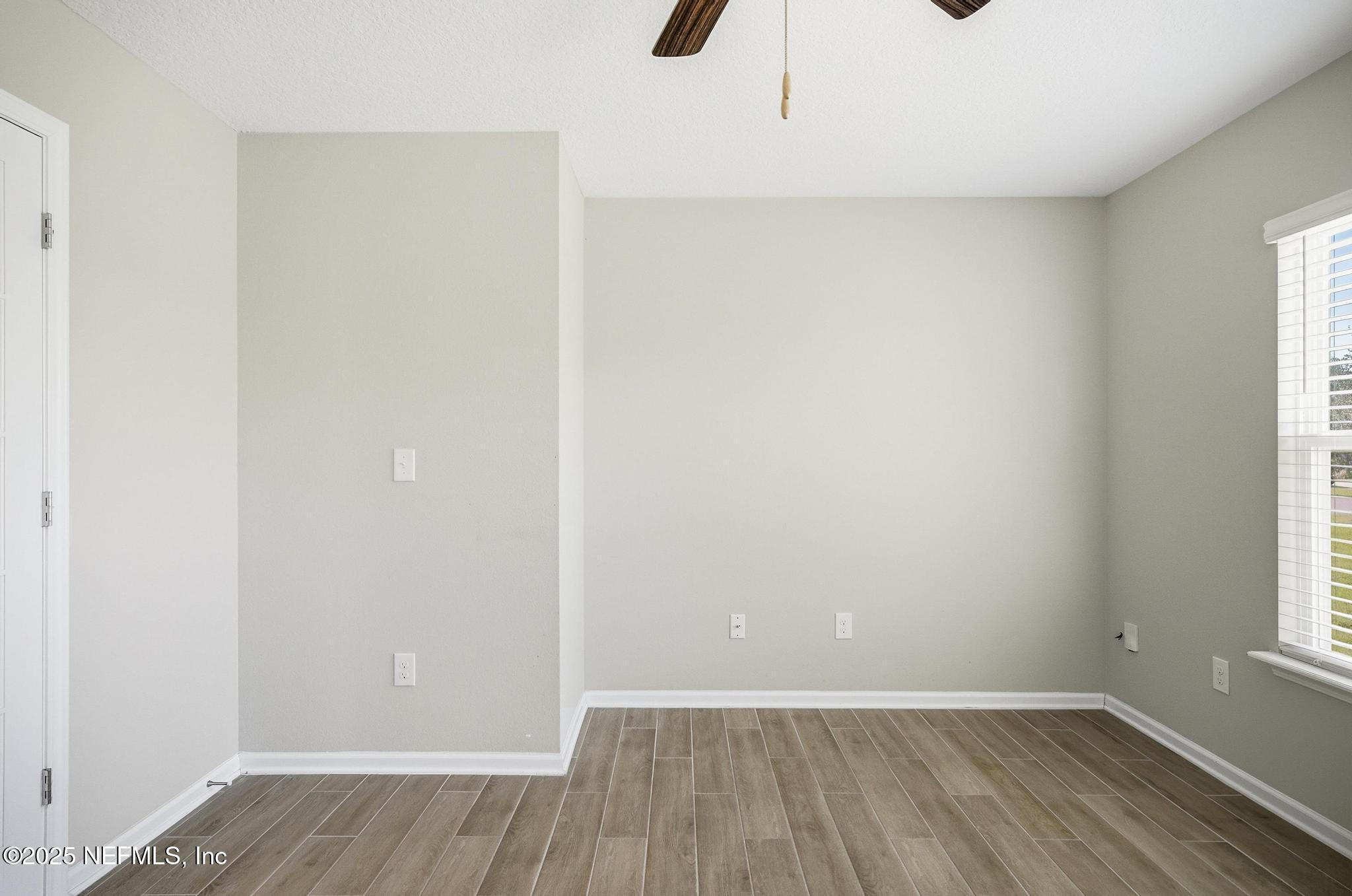 83 Hummingbird Court Palm Coast, FL 32164 - Photo 32 of 70 a view of an empty room with wooden floor and a window