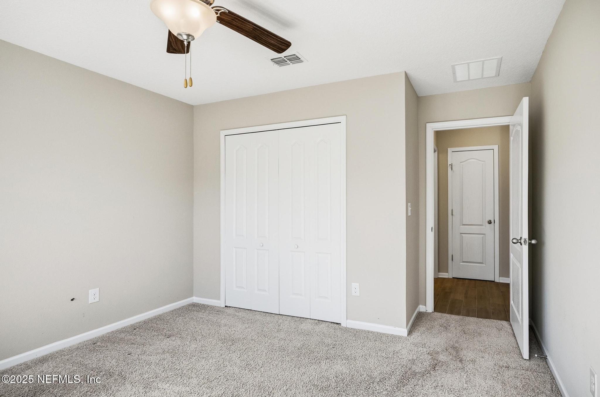 83 Hummingbird Court Palm Coast, FL 32164 - Photo 36 of 70 an empty room with closet and a chandelier fan