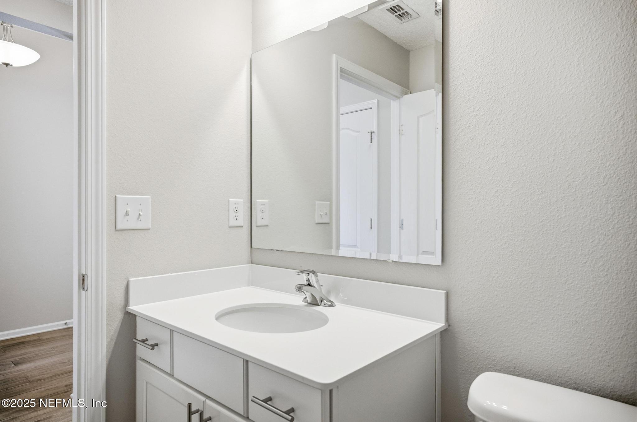 83 Hummingbird Court Palm Coast, FL 32164 - Photo 38 of 70 a bathroom with a toilet sink and mirror