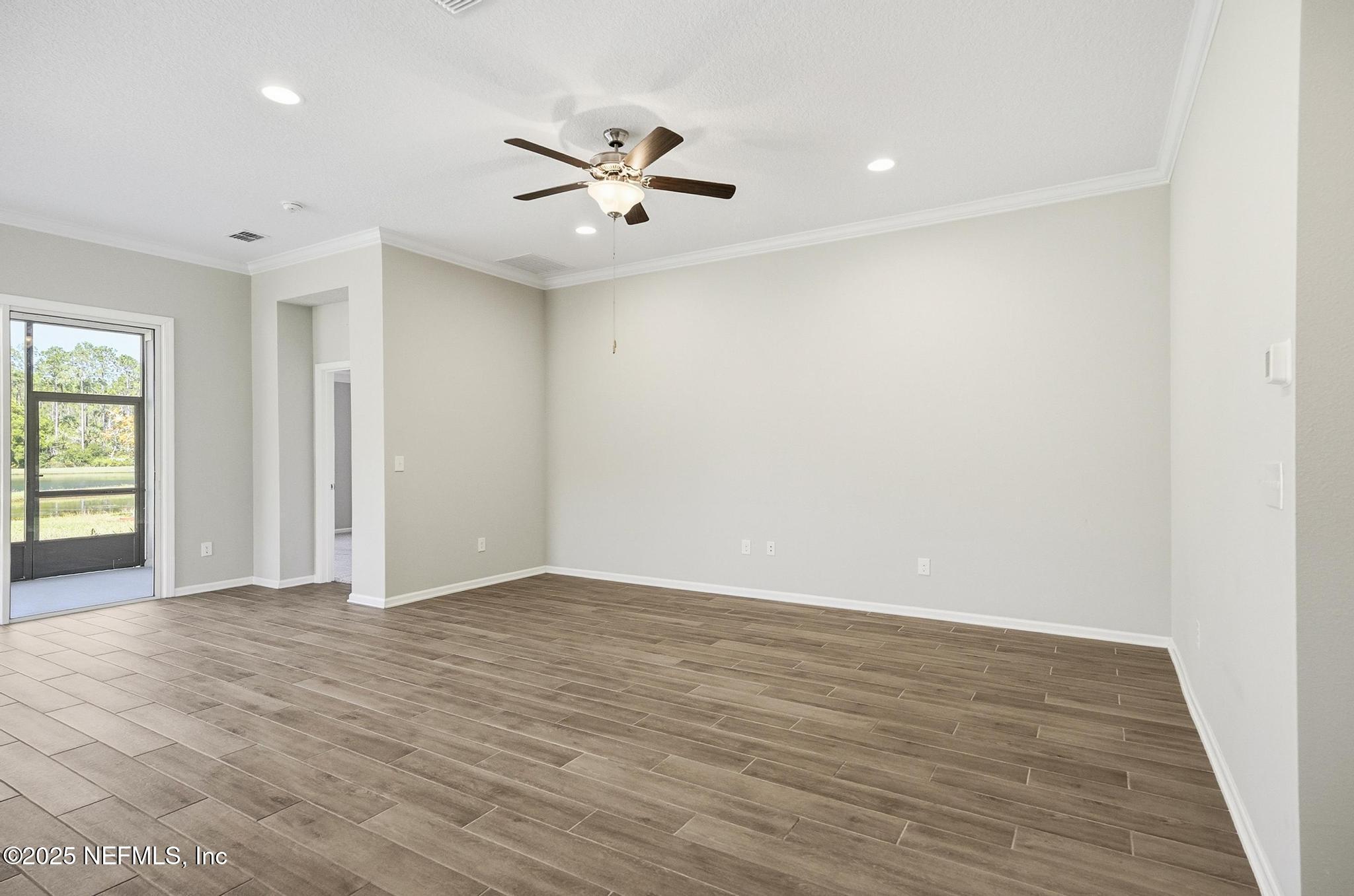 83 Hummingbird Court Palm Coast, FL 32164 - Photo 42 of 70 an empty room with wooden floor and windows