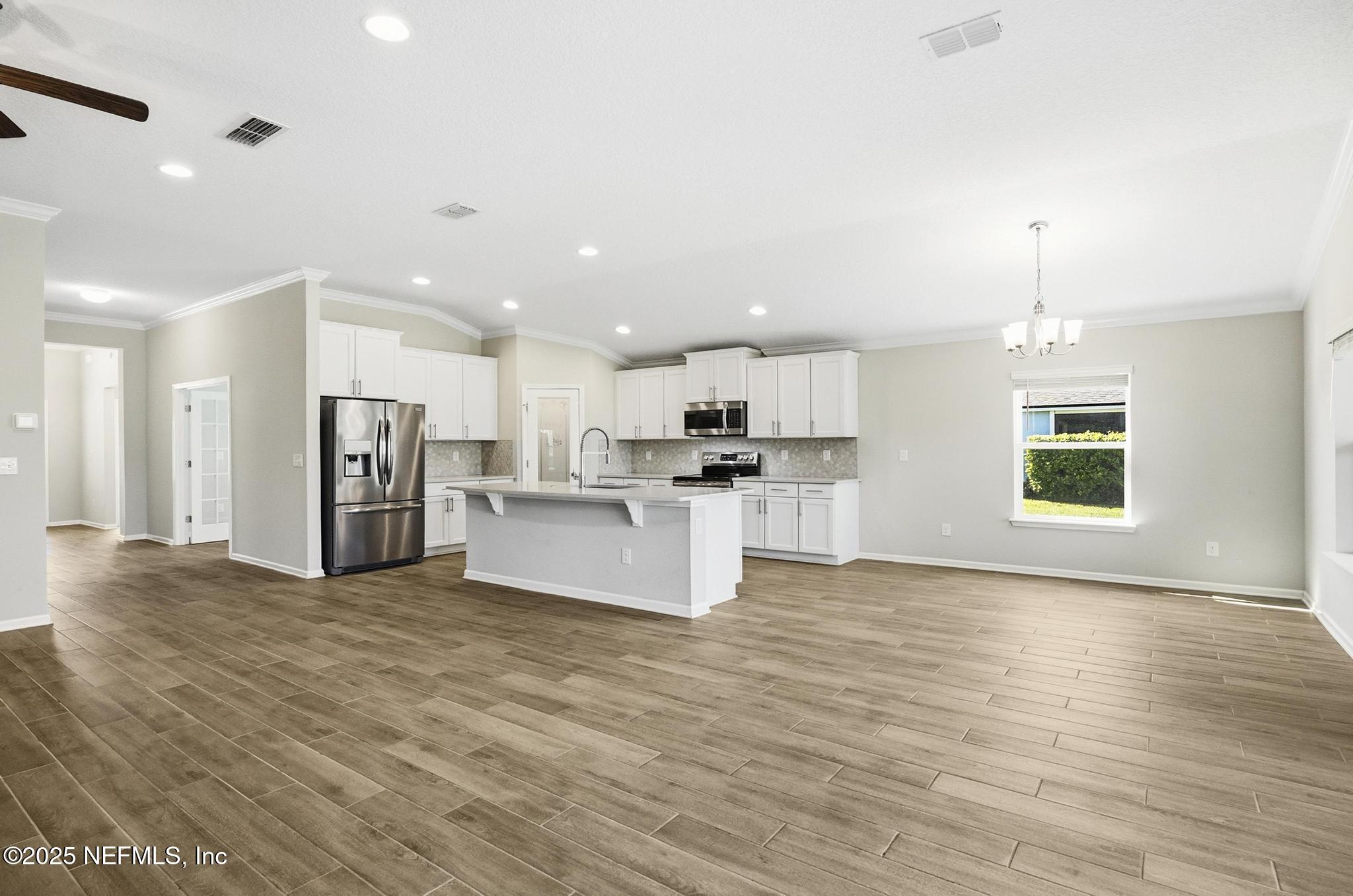 83 Hummingbird Court Palm Coast, FL 32164 - Photo 44 of 70 a view of kitchen with kitchen island wooden floor center island and appliances