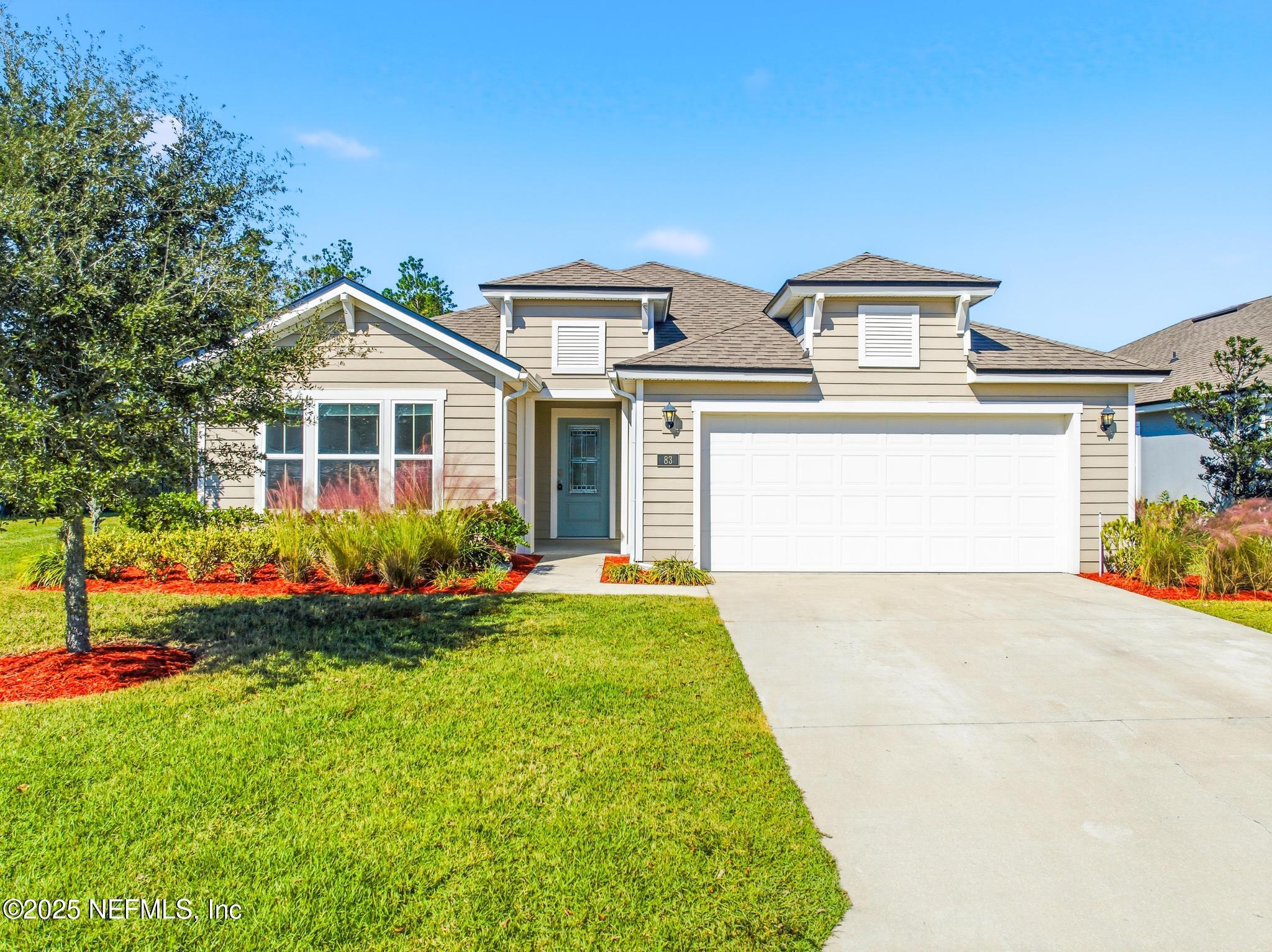 83 Hummingbird Court Palm Coast, FL 32164 - Photo 53 of 70 a front view of a house with a yard and garage
