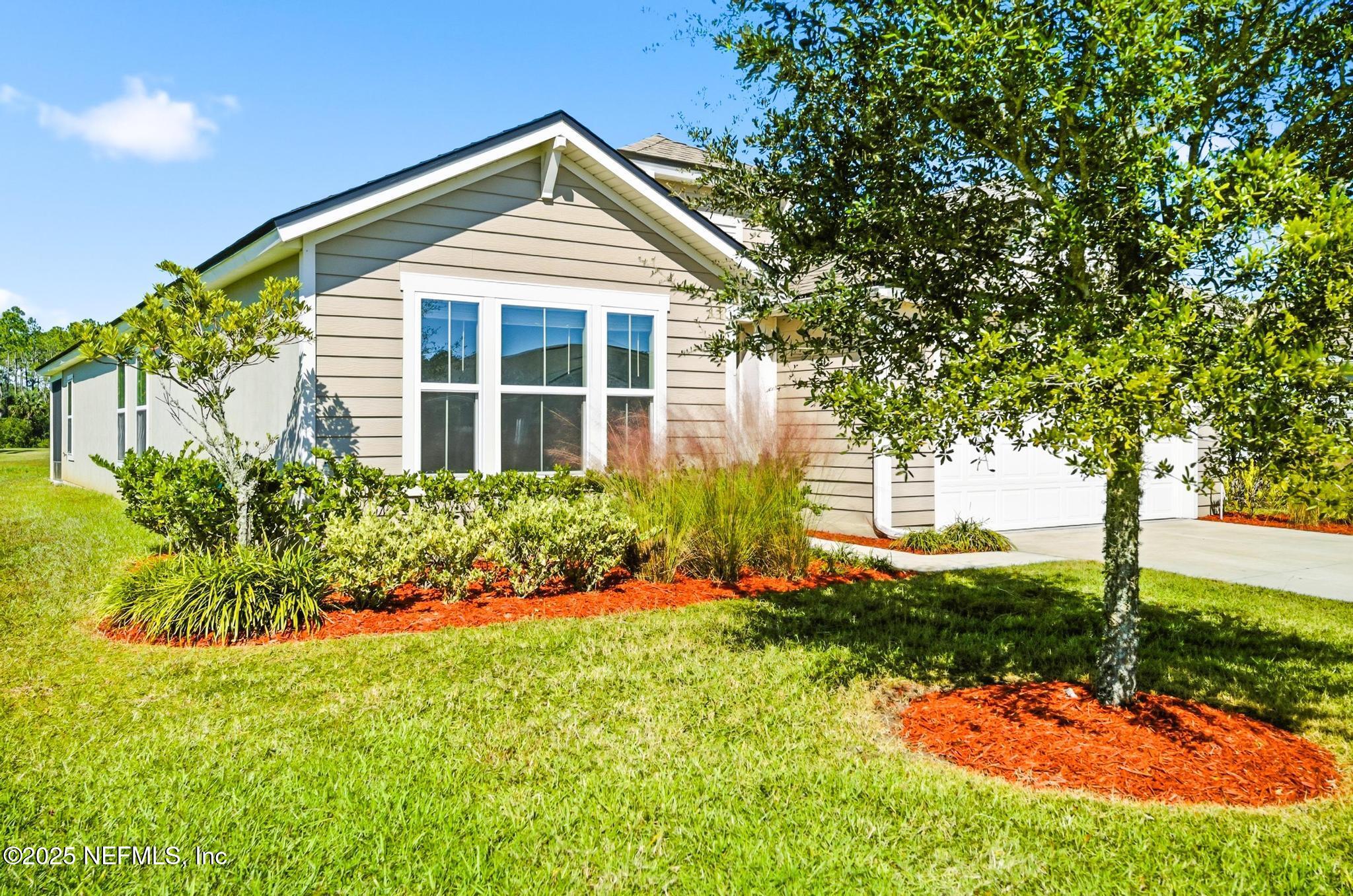 83 Hummingbird Court Palm Coast, FL 32164 - Photo 61 of 70 a front view of a house with a yard