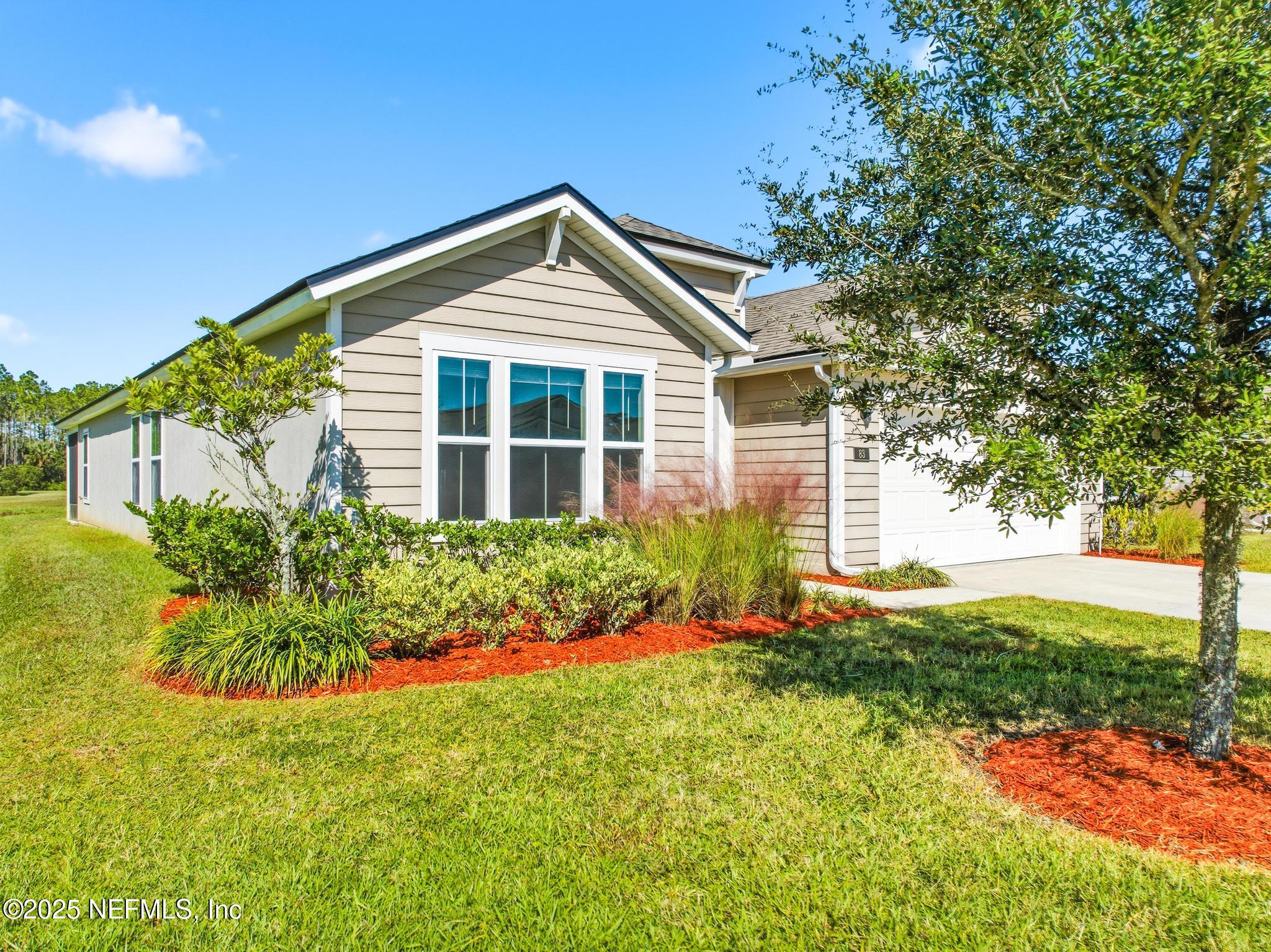 83 Hummingbird Court Palm Coast, FL 32164 - Photo 65 of 70 a front view of a house with a yard