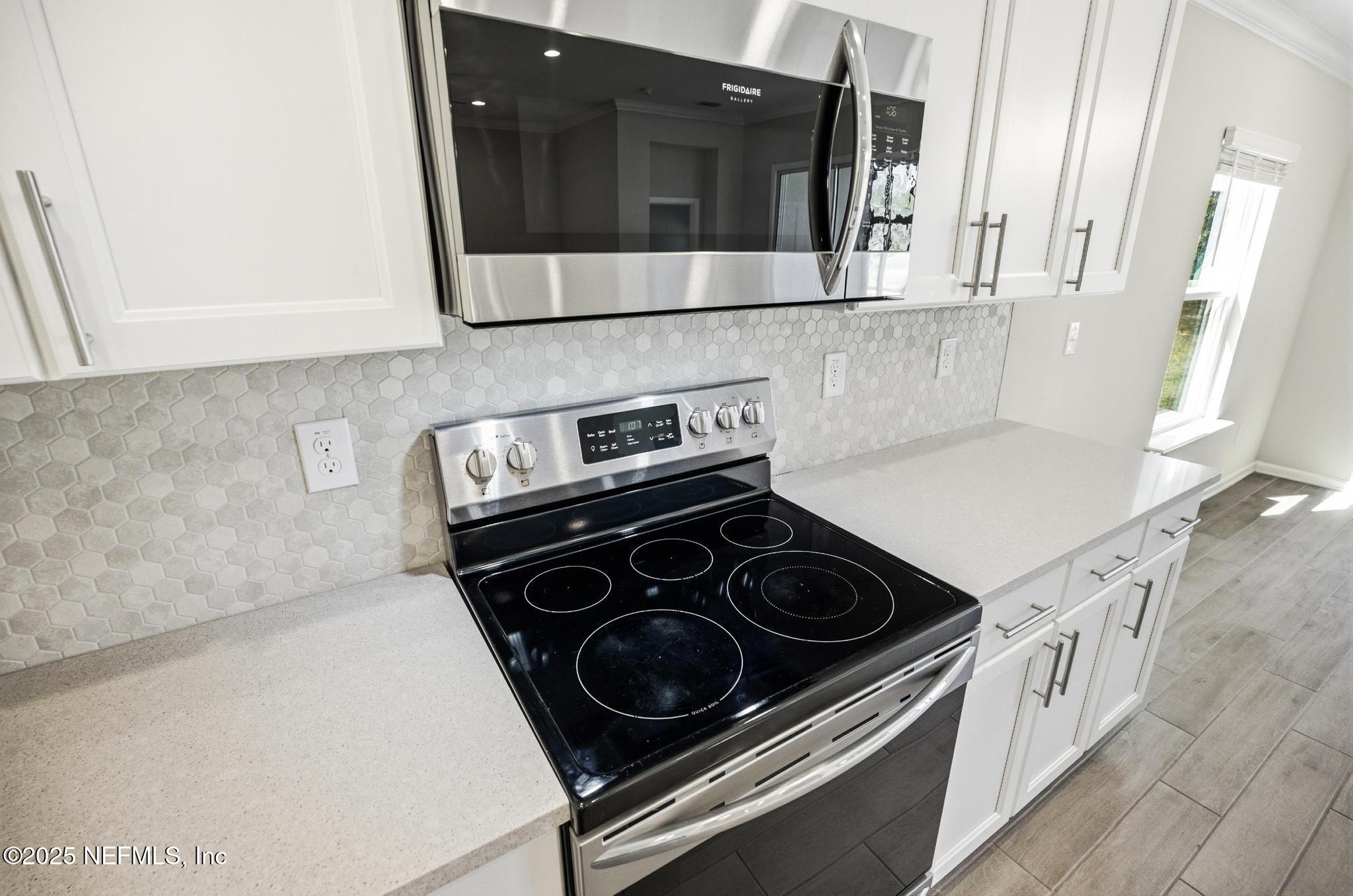 83 Hummingbird Court Palm Coast, FL 32164 - Photo 7 of 70 a kitchen with a stove and a microwave