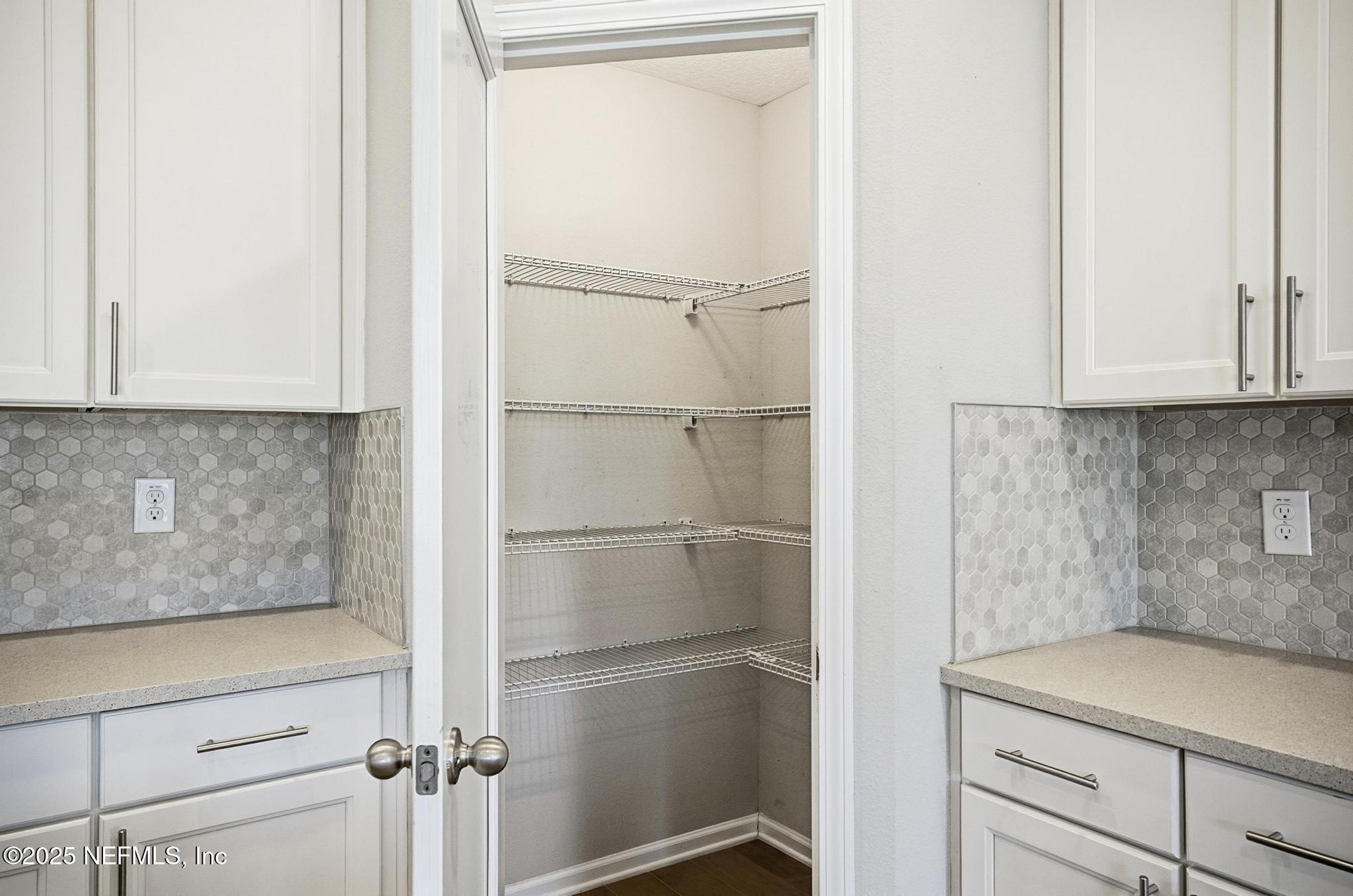 83 Hummingbird Court Palm Coast, FL 32164 - Photo 8 of 70 a view of a kitchen with white cabinets and a refrigerator