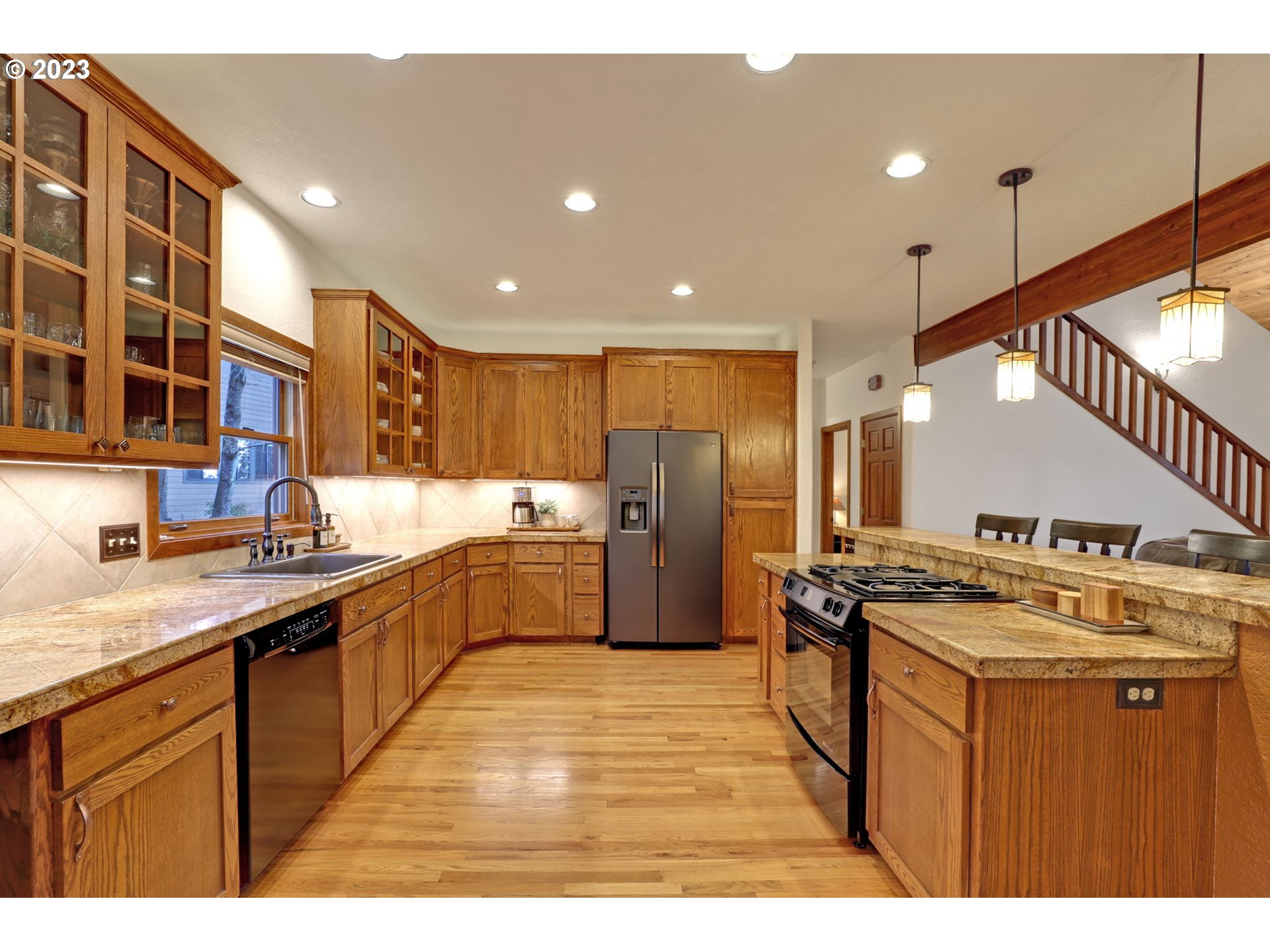 12434 Southwest 57th Avenue Portland, OR 97219 - Photo 11 of 34 a kitchen with stainless steel appliances granite countertop a sink a stove and a refrigerator