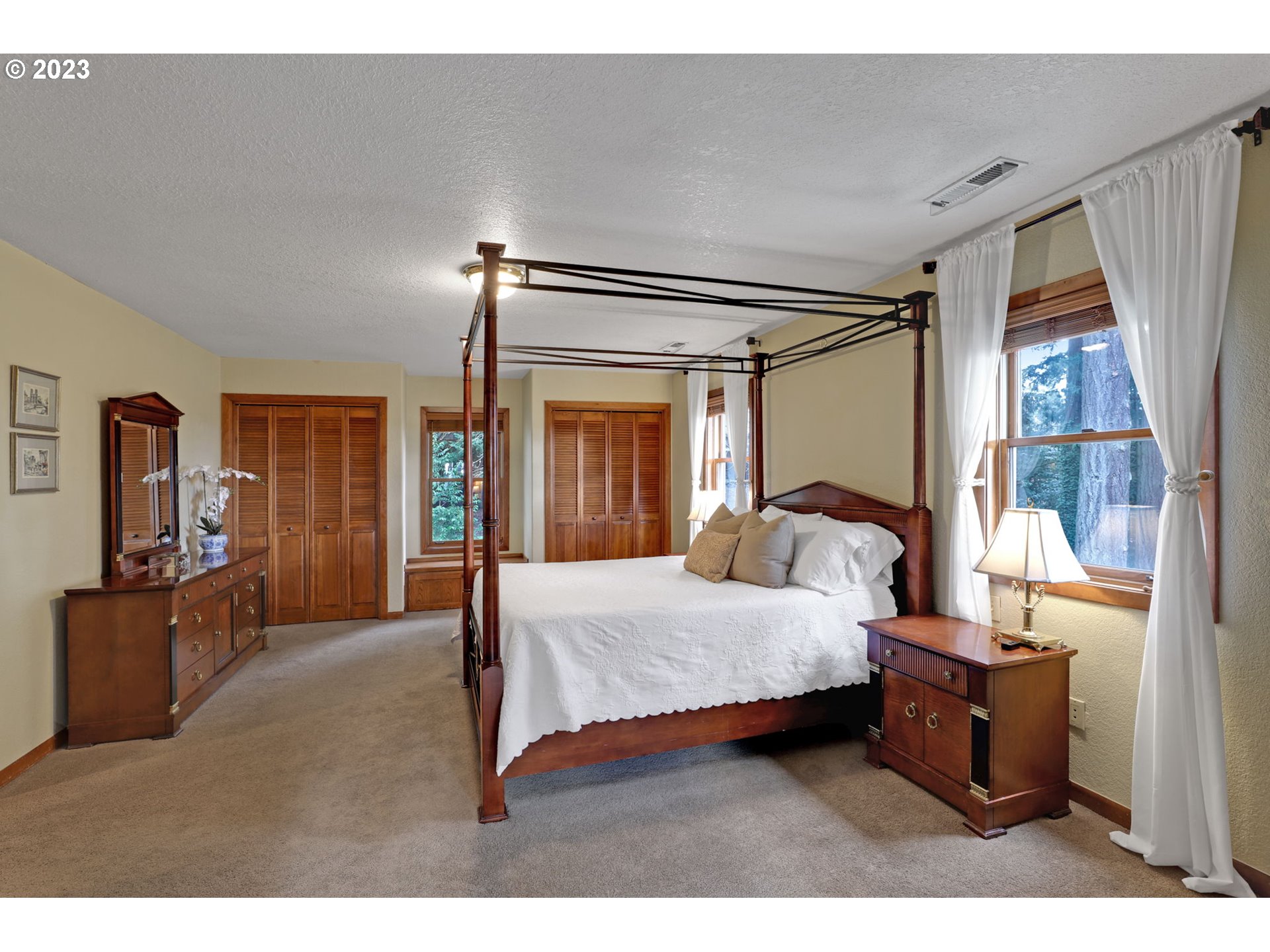 12434 Southwest 57th Avenue Portland, OR 97219 - Photo 16 of 34 a bedroom with a bed and large mirror with window