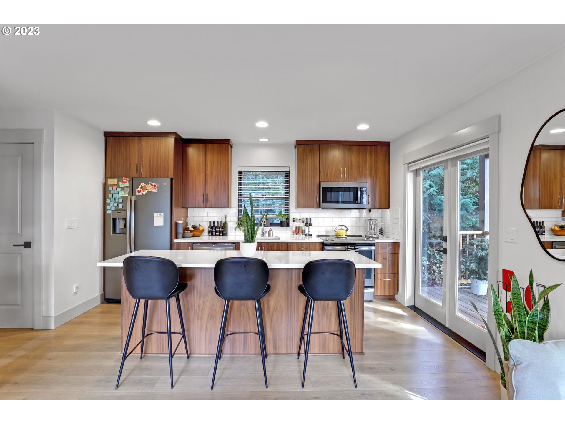 12434 Southwest 57th Avenue Portland, OR 97219 - Photo 28 of 34 a kitchen with stainless steel appliances granite countertop a refrigerator a oven a sink and a dining table with wooden floor