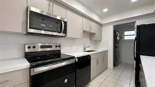 a kitchen with stainless steel appliances a stove microwave and sink