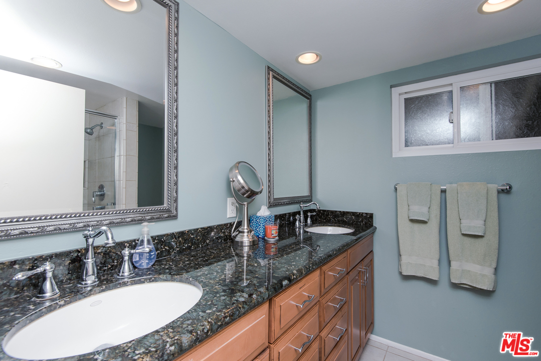 5533 Jon Dodson Drive Agoura Hills, CA 91301 - Photo 15 of 23 a bathroom with a granite countertop sink a mirror and shower