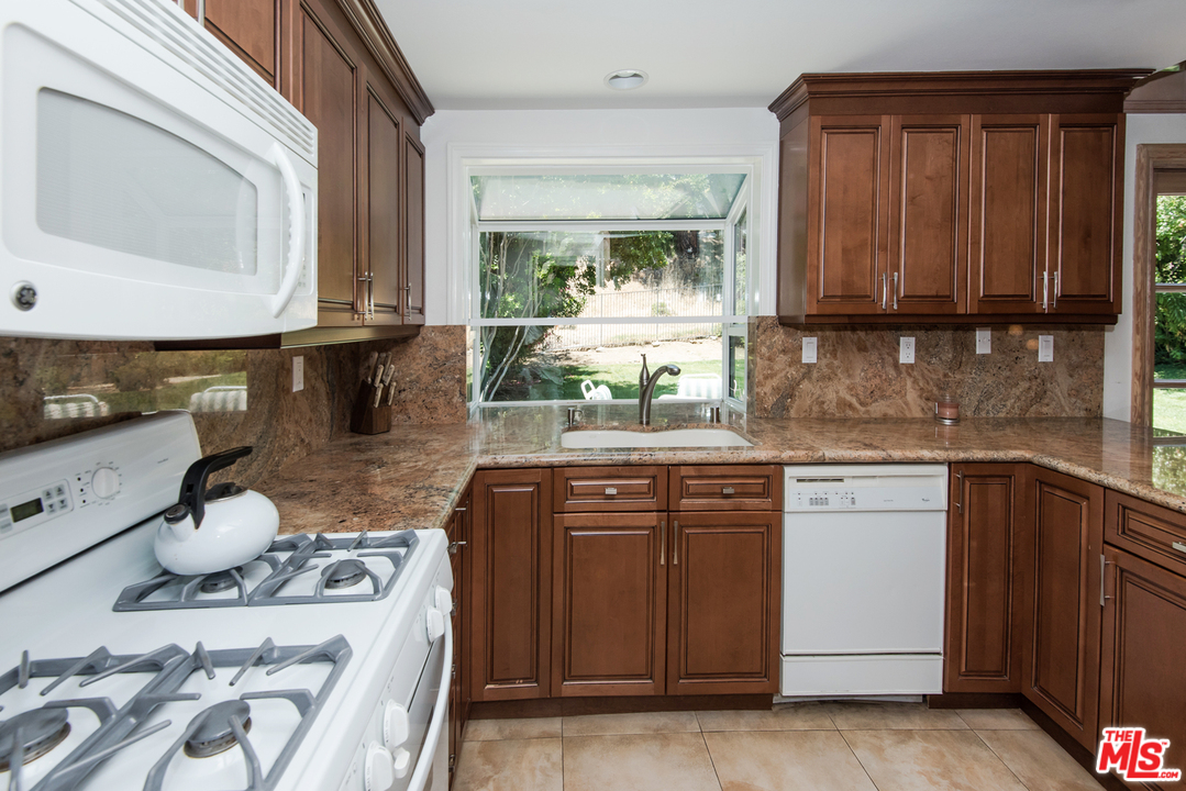 5533 Jon Dodson Drive Agoura Hills, CA 91301 - Photo 4 of 23 a kitchen with stainless steel appliances granite countertop a stove a sink and a microwave