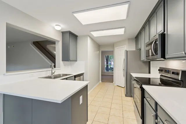 a kitchen with a refrigerator a sink a stove and cabinets