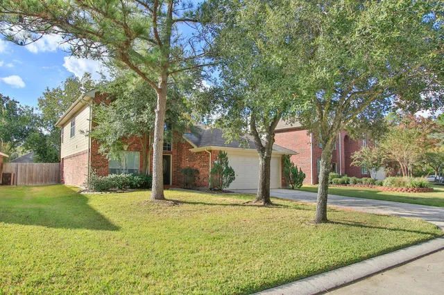 a view of a house with backyard and tree