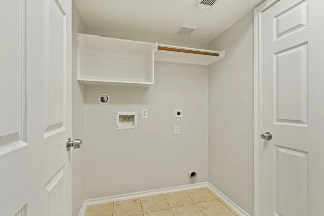 a view of an empty room and chandelier fan