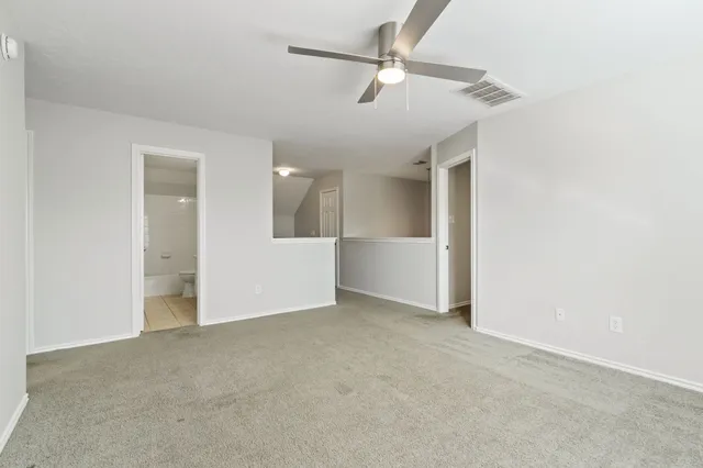 an empty room with a window and a fan