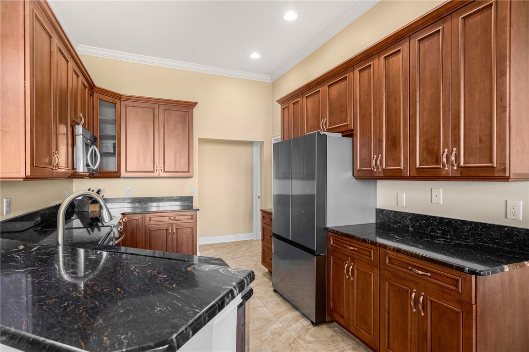 7635 Agawam Road Micco, FL 32976 - Photo 14 of 36 a kitchen with stainless steel appliances granite countertop a sink a stove and a refrigerator