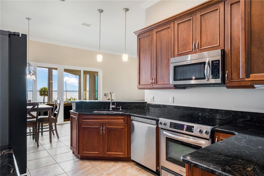 7635 Agawam Road Micco, FL 32976 - Photo 16 of 36 a kitchen with granite countertop a stove a sink and dishwasher wooden cabinets with a granite countertops