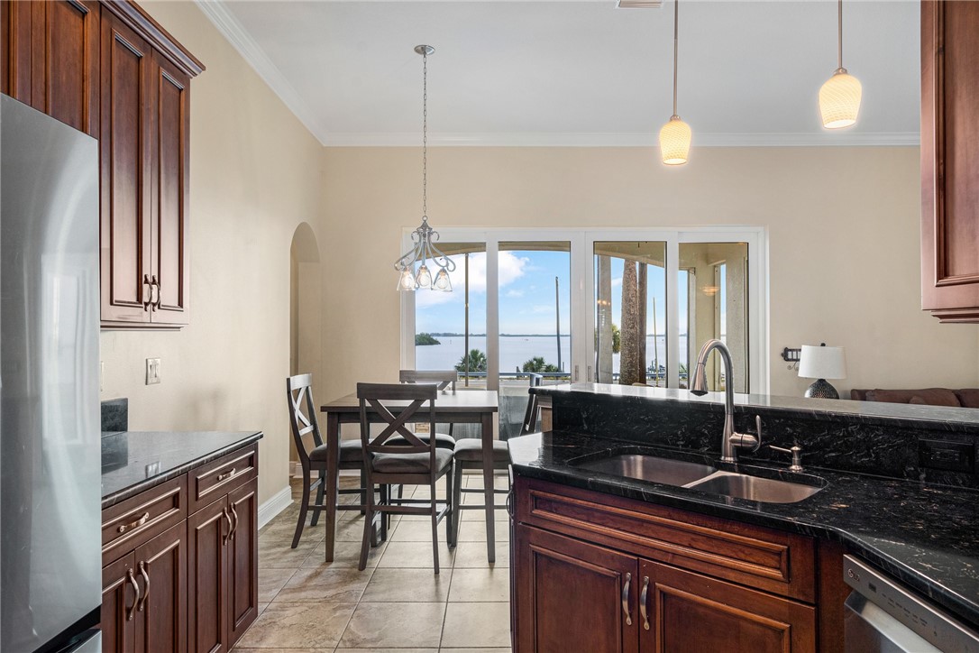 7635 Agawam Road Micco, FL 32976 - Photo 17 of 36 a kitchen with sink table and chairs