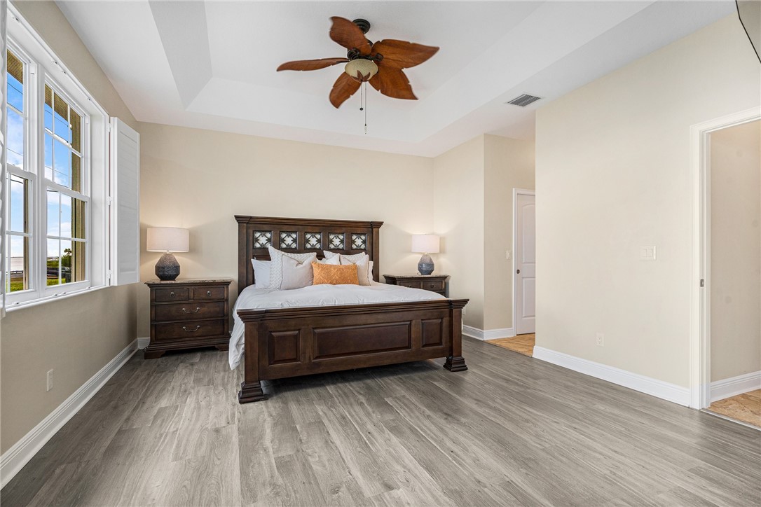 7635 Agawam Road Micco, FL 32976 - Photo 19 of 36 a bedroom with a bed and a chandelier