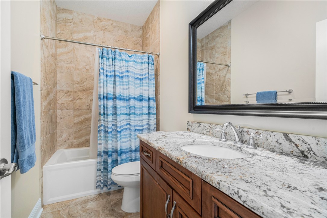 7635 Agawam Road Micco, FL 32976 - Photo 25 of 36 a bathroom with a granite countertop sink toilet and shower