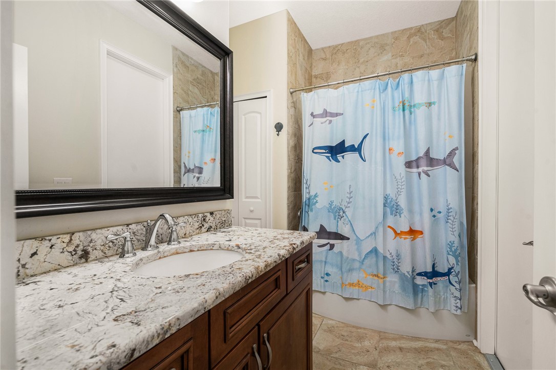 7635 Agawam Road Micco, FL 32976 - Photo 28 of 36 a bathroom with a granite countertop sink and a mirror