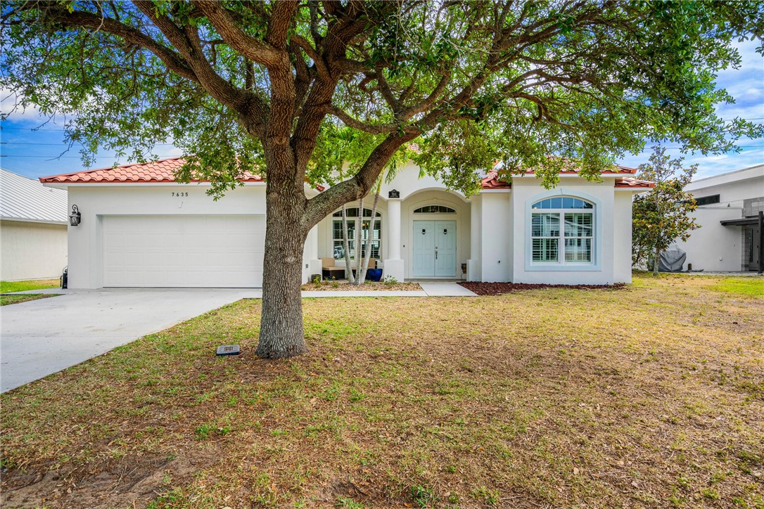 7635 Agawam Road Micco, FL 32976 - Photo 3 of 36 a house with trees in front of it