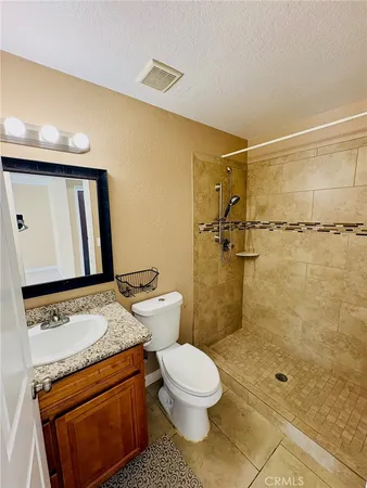 a bathroom with a granite countertop sink toilet and shower