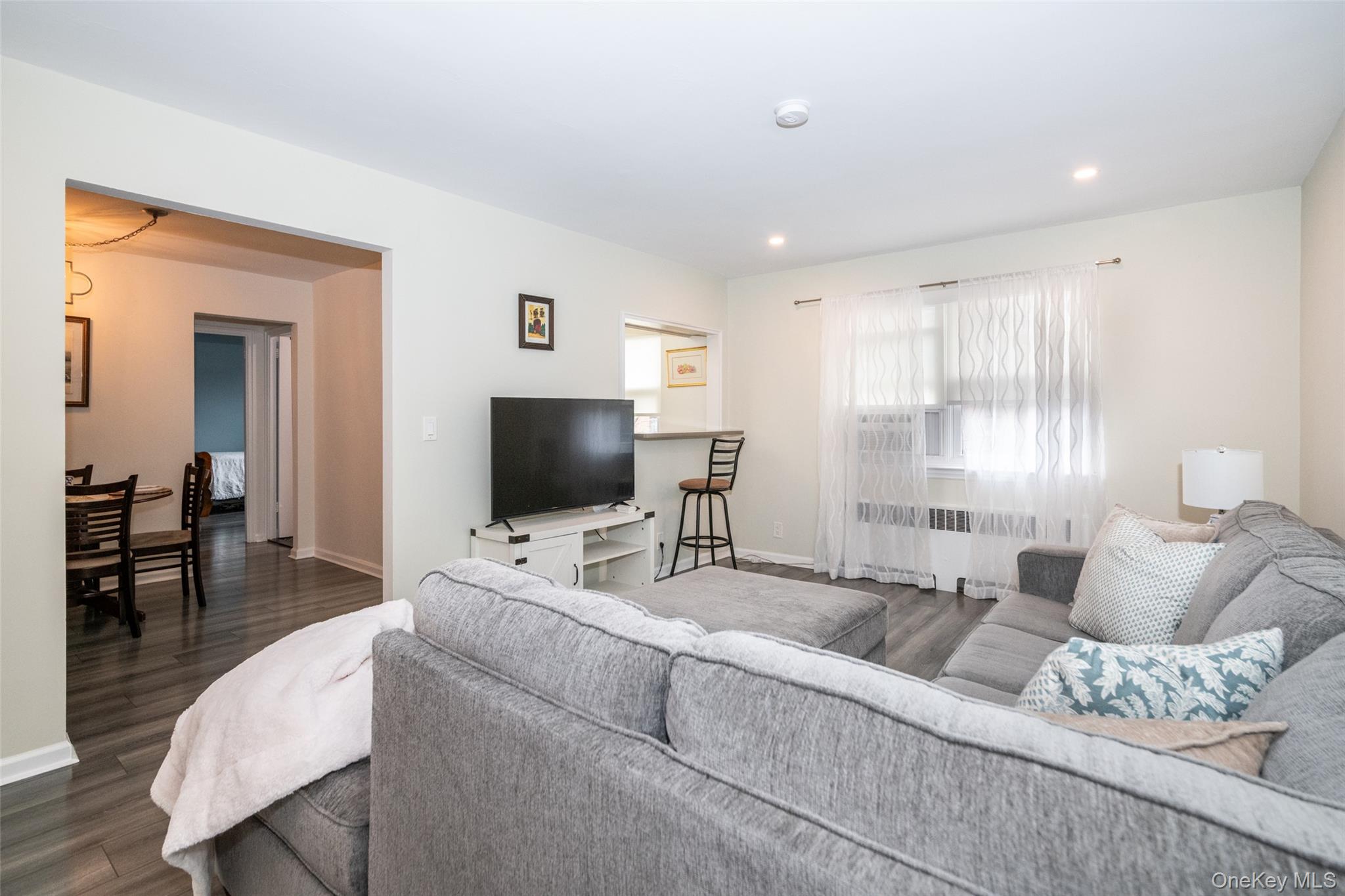 450 Pelham Road, Unit 3H New Rochelle, NY 10805 - Photo 12 of 16 a living room with furniture and a flat screen tv