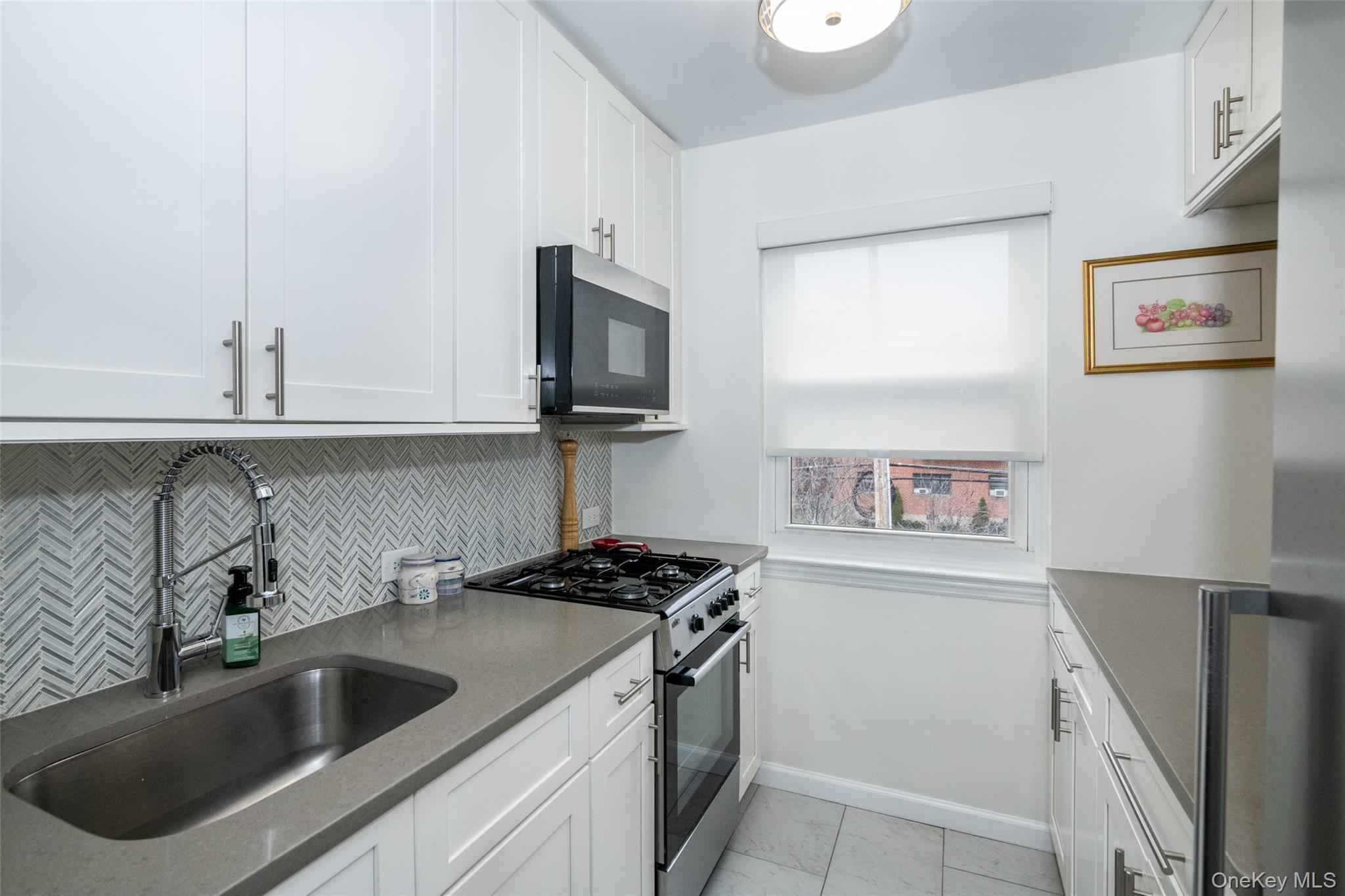 450 Pelham Road, Unit 3H New Rochelle, NY 10805 - Photo 6 of 16 a kitchen with stainless steel appliances granite countertop a sink and a stove