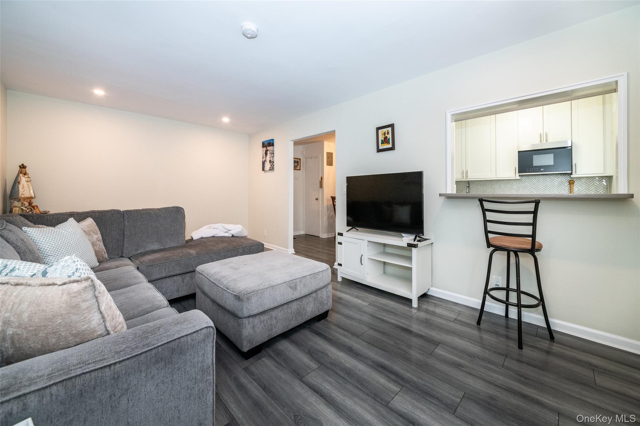 450 Pelham Road, Unit 3H New Rochelle, NY 10805 - Photo 8 of 16 a living room with furniture and a flat screen tv