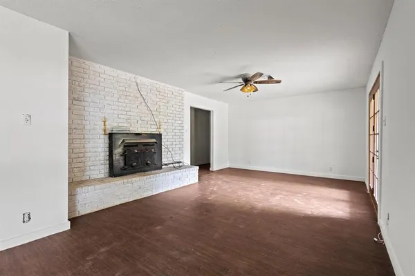 an empty room with windows and fireplace