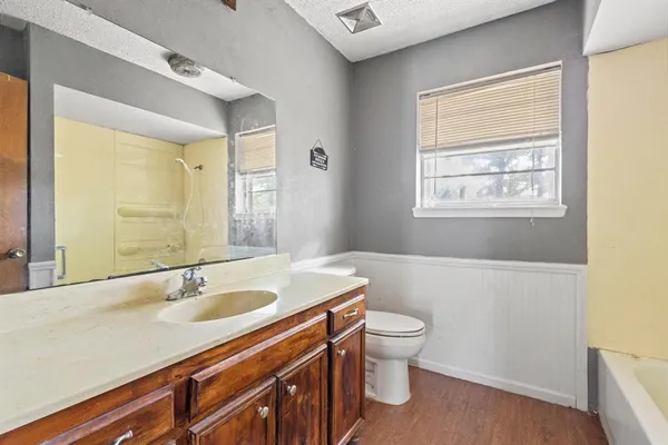 a bathroom with a sink a toilet and a large mirror