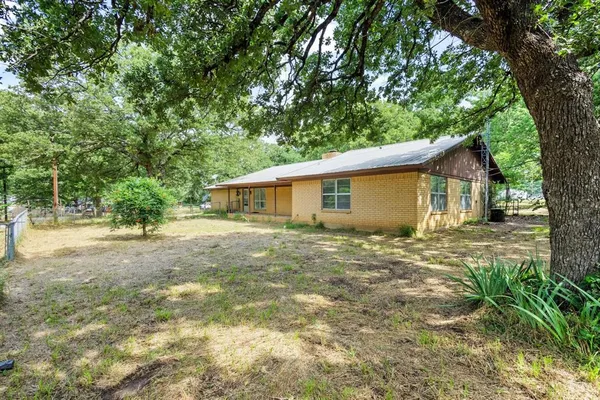 a view of a house with backyard and a tree