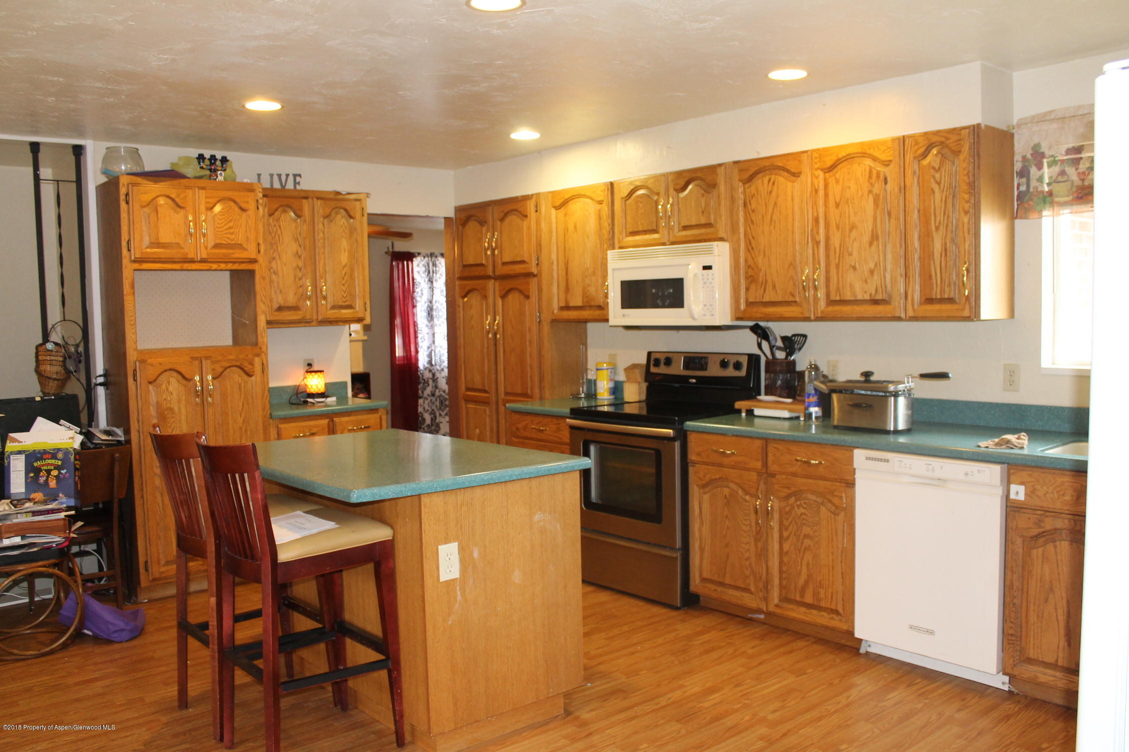 405 Ute Avenue Rifle, CO 81650 - Photo 11 of 21 a kitchen with stainless steel appliances granite countertop a sink a stove a refrigerator cabinets and dining table