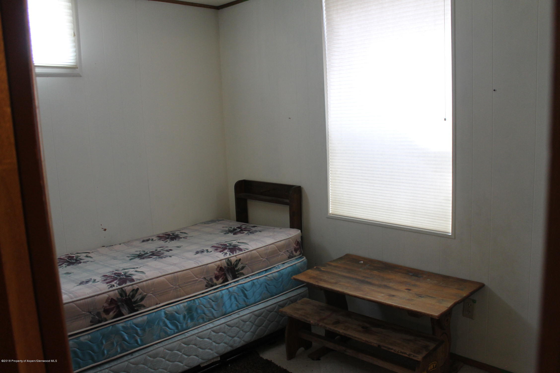405 Ute Avenue Rifle, CO 81650 - Photo 12 of 21 a bedroom with a bed and a window