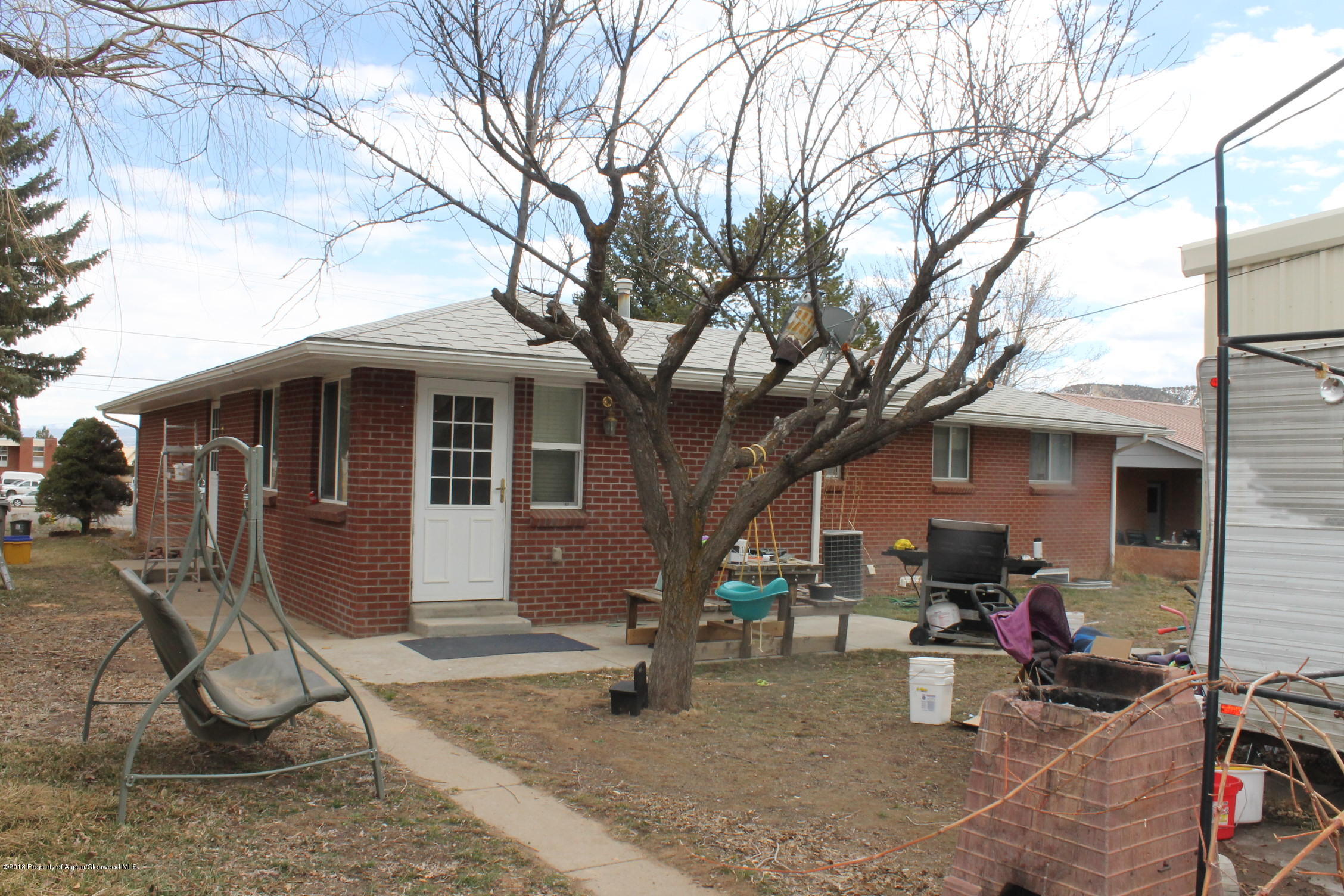 405 Ute Avenue Rifle, CO 81650 - Photo 20 of 21 a view of a house with patio chairs and a tree