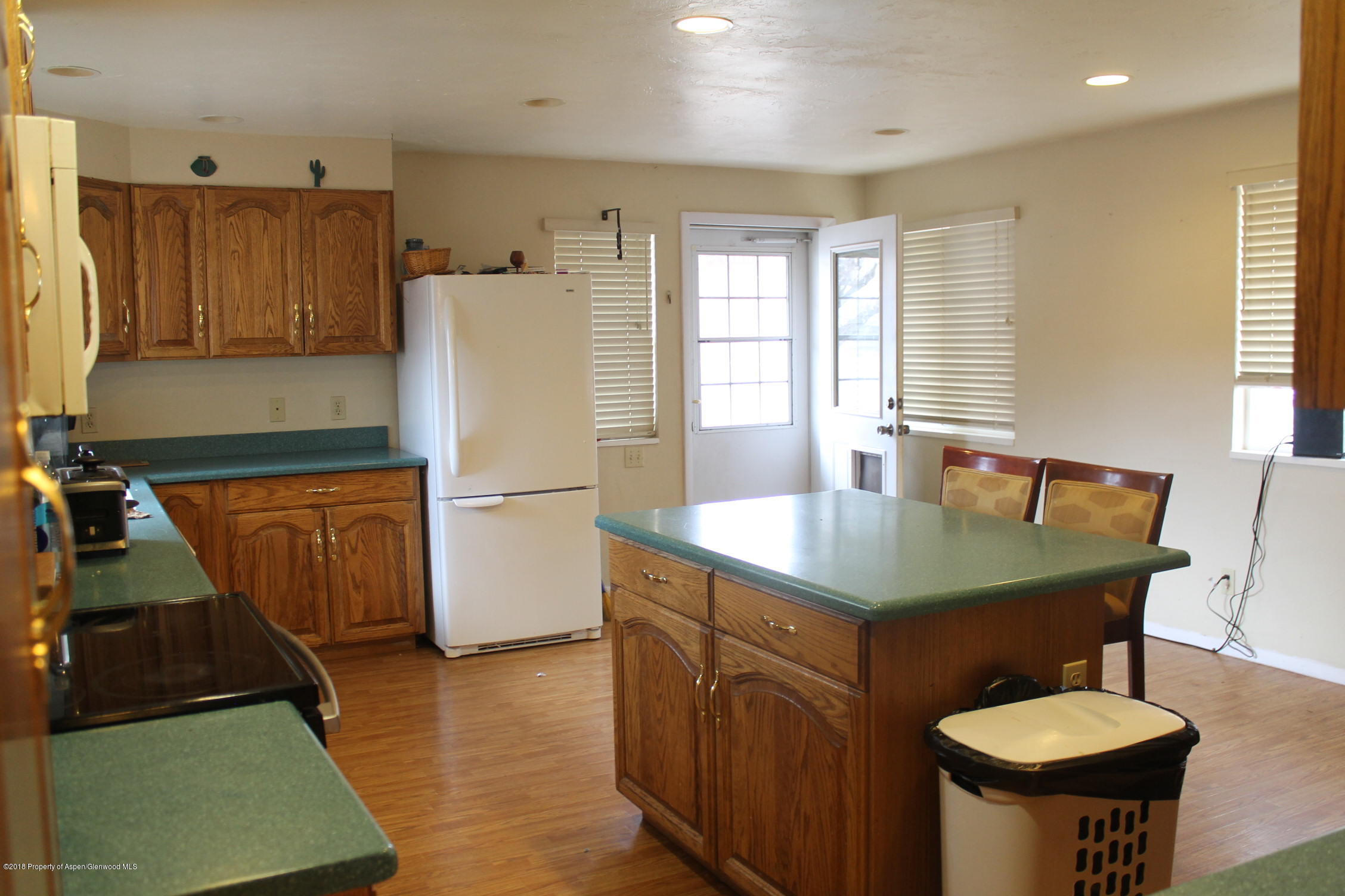 405 Ute Avenue Rifle, CO 81650 - Photo 10 of 21 a kitchen with a sink a refrigerator and wooden floor