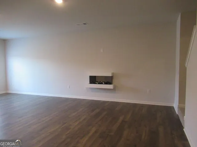a view of an empty room and wooden floor
