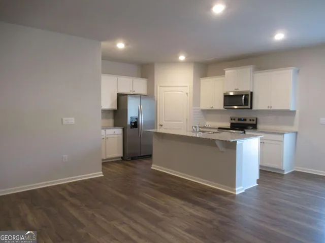 a kitchen with a refrigerator and a stove top oven