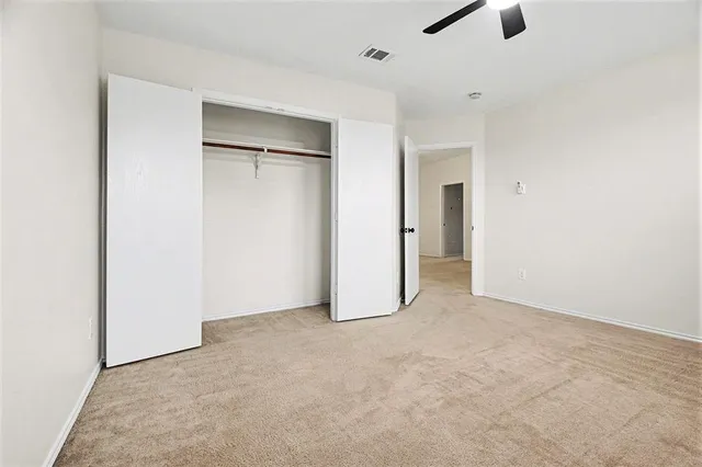 an empty room with closet and windows