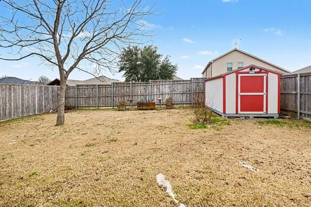 a view of a house with a yard and wooden fence