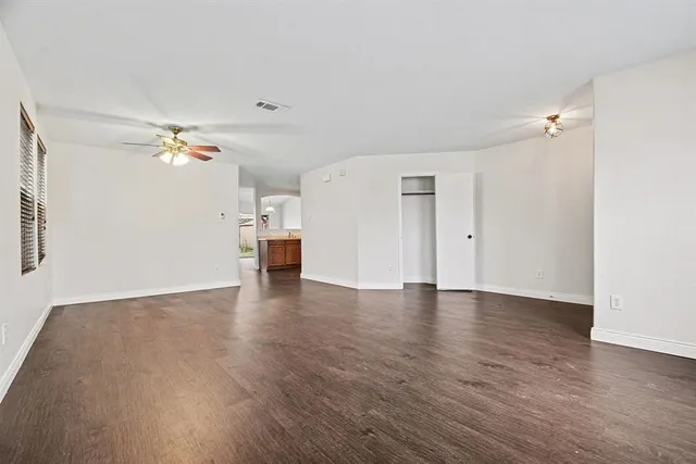 a view of an empty room with wooden floor