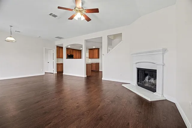 a view of an empty room with a fireplace and a window