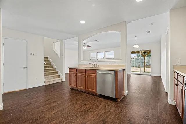 a kitchen with wooden floors and white walls