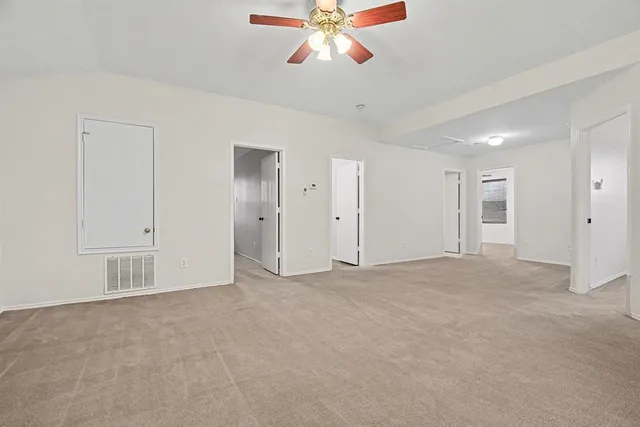 a view of an empty room with a ceiling fan