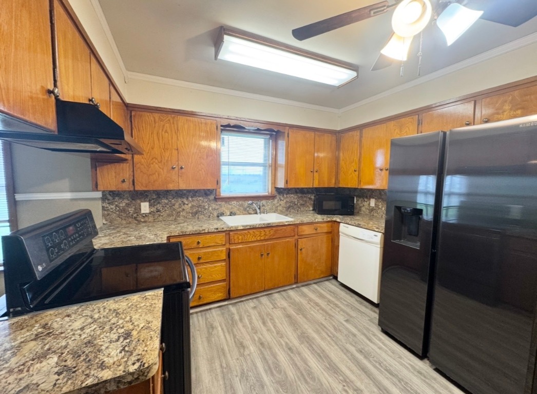 110 Marek Road Elgin, TX 78621 - Photo 8 of 27 a kitchen with granite countertop a refrigerator a sink dishwasher a stove and white cabinets with wooden floor
